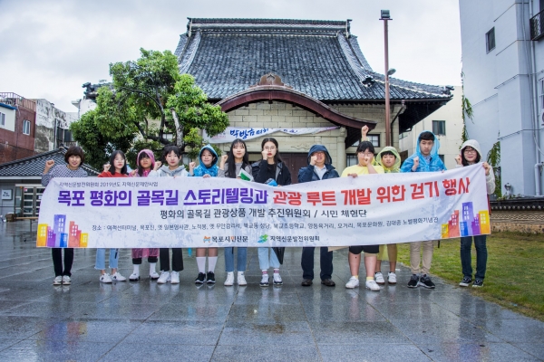 목포시민신문사는 지난 21일 시민과 청소년들이 참여하는 평화의 골목길 관광루트개발 현장점검을 실시했다. 걷기 행사가 마무리되고 참가자들이 오거리문화센터에서 사진촬영을 하고 있다.